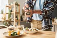 Homme ajoutant épices sur salade - Man adding spices on salad