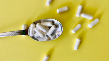 Suppléments dans une cuillère sur fond jaune