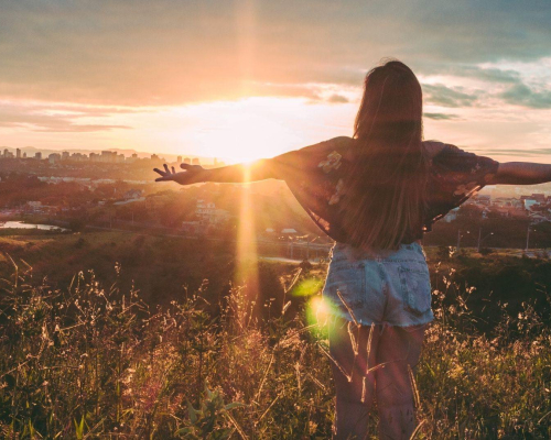 Femme regardant le coucher du soleil