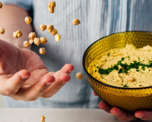 plat de hummus avec pois chiche sec à côté