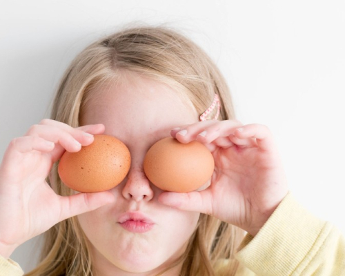 enfant se cachant les yeux avec des oeufs