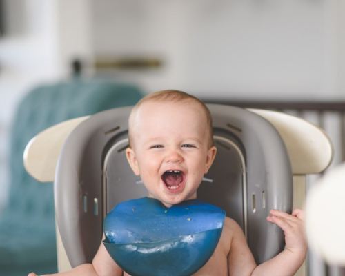 bébé souriant sur la chaise haute