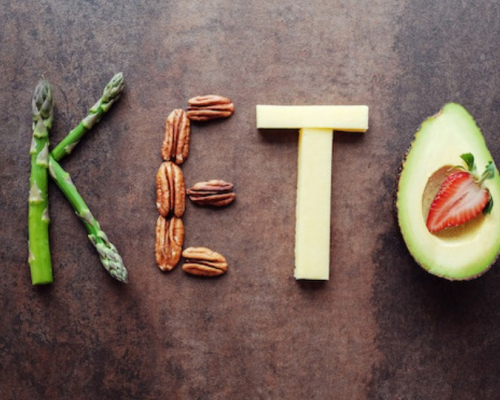 Keto écrit sur un fond de bois avec des légumes et des protéines