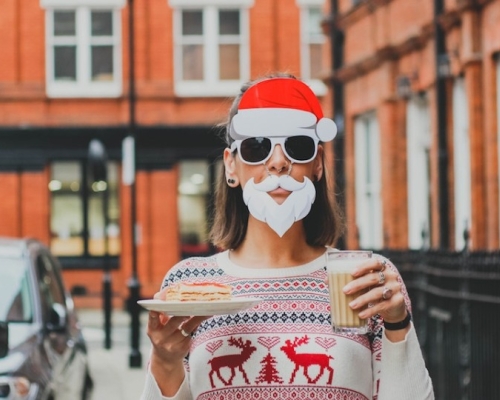 femme déguisée en père noel et tenant un verre de lait de poule et un dessert