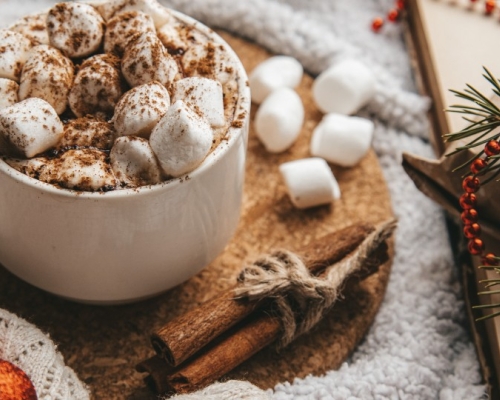 chocolat chaud avec guimauves sur une tables décorée pour Noël