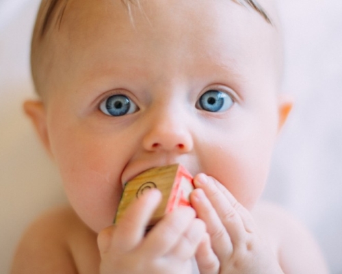 bébé aux yeux bleus qui fait ses dents