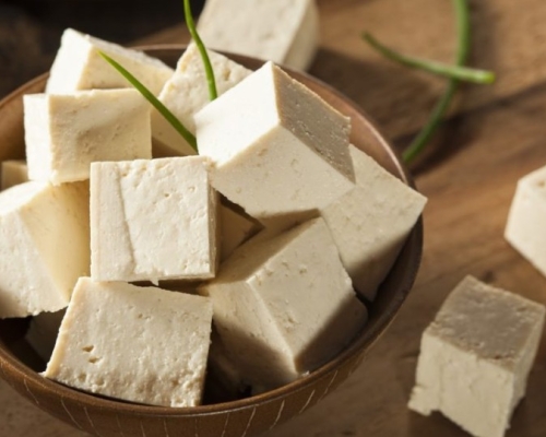 Petits cubes de tofu dans un petit bol en bois