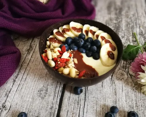 Bol de yogourt et/ou smoothie sur un fond de bois avec une couverture mauve