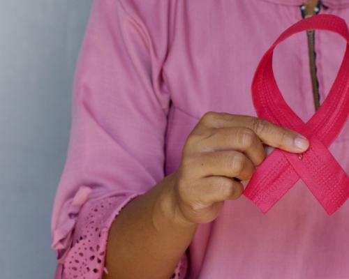 femme qui tient un ruban rose représentant le cancer du sein