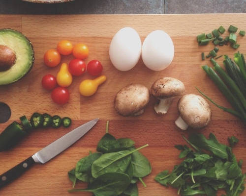 légumes et protéines sur une planche à découper en bois