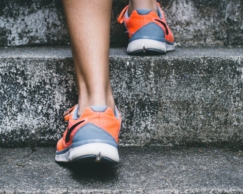 individu montant les escaliers avec ses souliers de sport