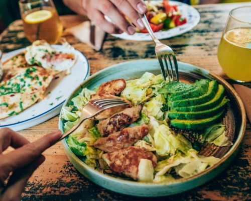 Chicken and avocado salad with forks digging in.