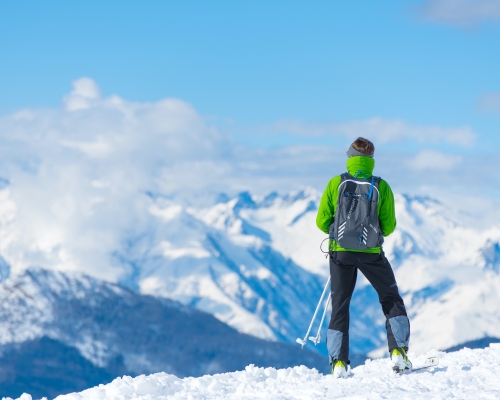 Homme sur une montagne enneigée regardant au loin