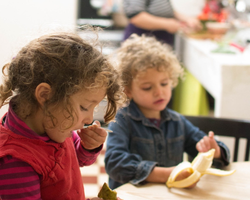 deux fillettes qui goûtent à des fruits