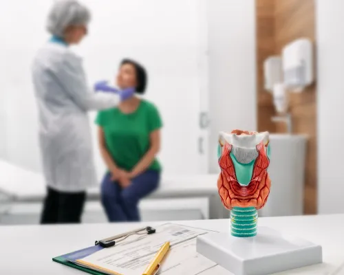 médecin palpe le cou de la femme pour le diagnostic des maladies thyroïdiennes
