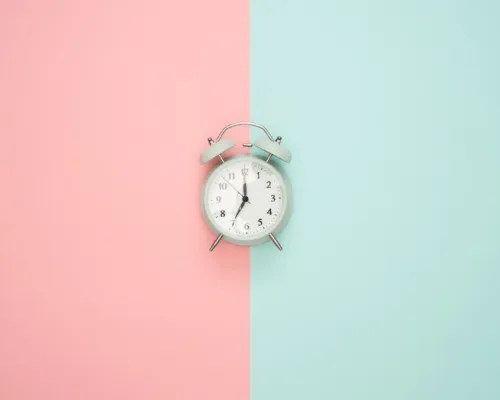 horloge au centre d'un fond moitié rose et moitié turquoise