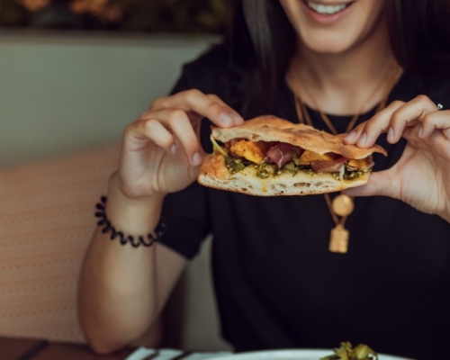 Dame qui mange un sandwich en pleine conscience au restaurant