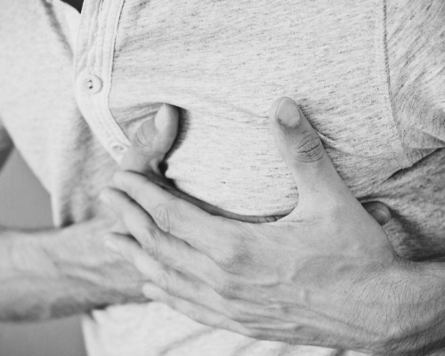 homme avec les mains sur le torse à cause de reflux gastriques