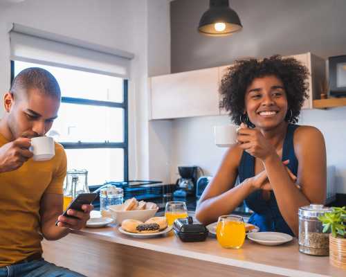 Young couple having breakfast at home