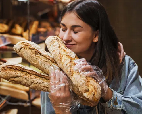 Femme sentant des baguettes de pain - Woman smelling bread