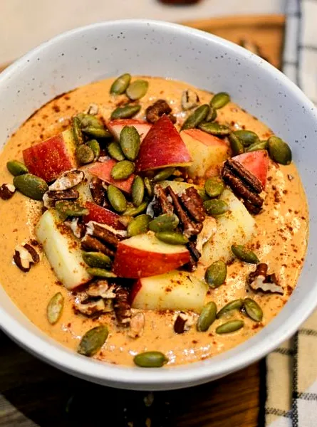 bol smoothie avec cubes de pommes et graines de citrouilles