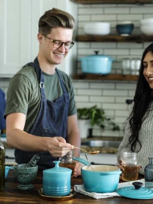 homme et femme souriants en cuisinant