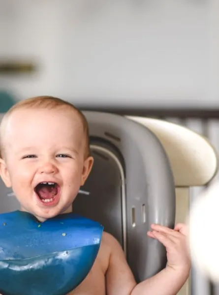 bébé souriant sur la chaise haute