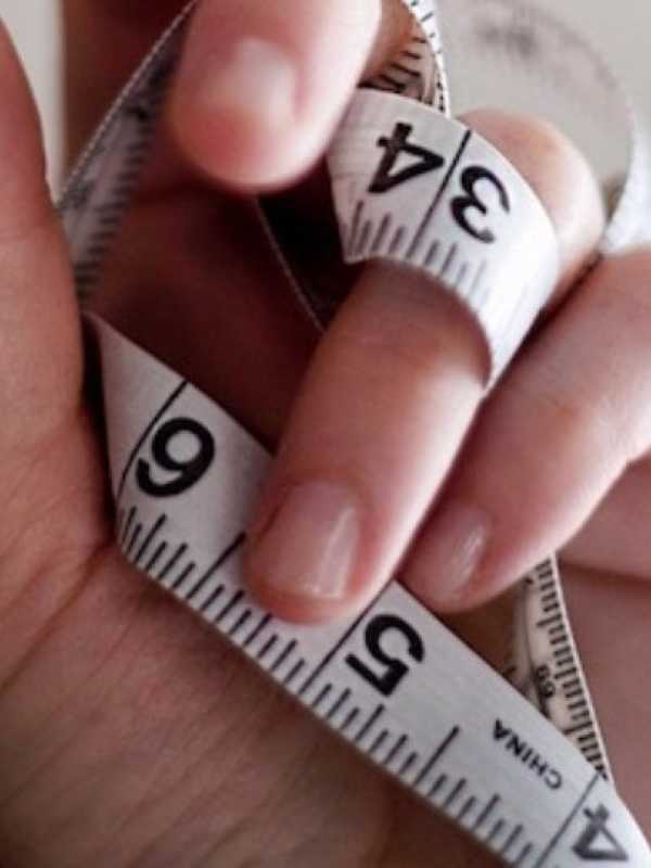 main qui tien un ruban à mesurer