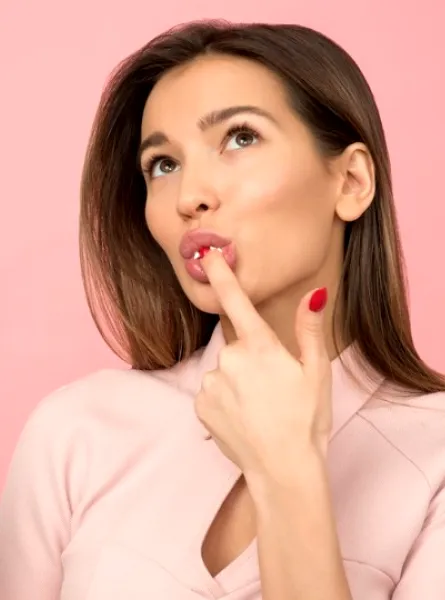 Femme qui mange un gateau devant un écran rose