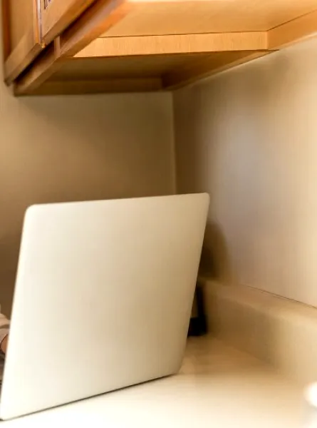 femme ménopausé devant un ordinateur avec un verre de lait