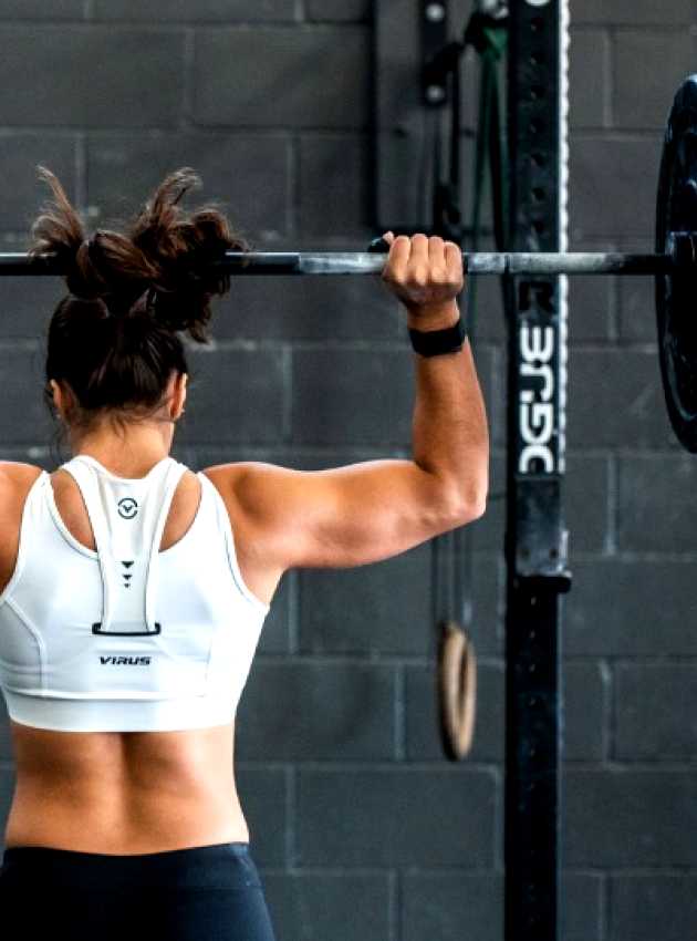 femme de dos musclée qui lève un haltère