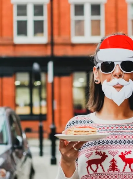 femme déguisée en père noel et tenant un verre de lait de poule et un dessert