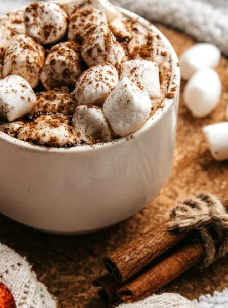 chocolat chaud avec guimauves sur une tables décorée pour Noël