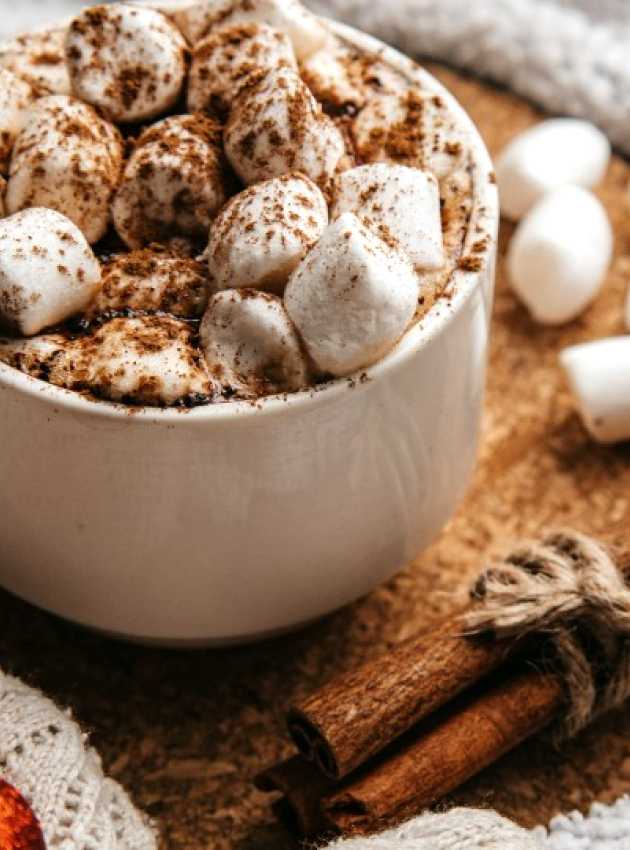 chocolat chaud avec guimauves sur une tables décorée pour Noël