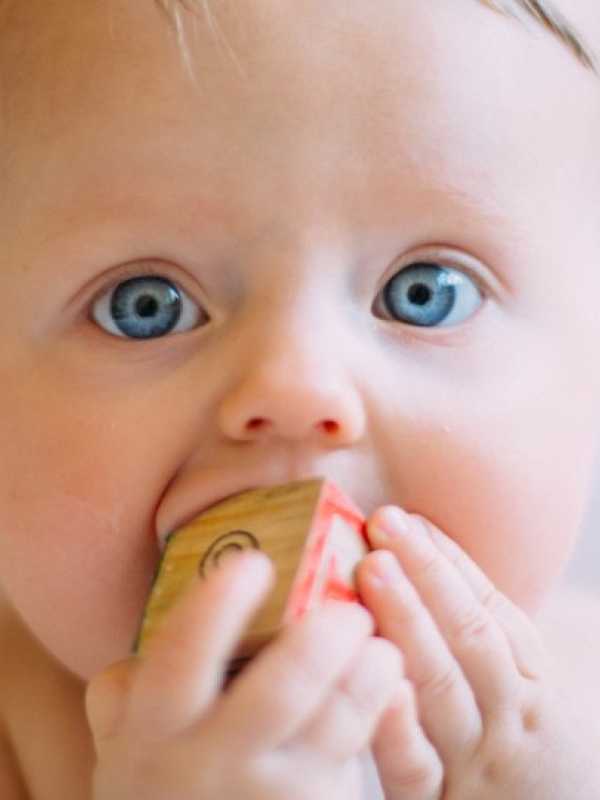 bébé aux yeux bleus qui fait ses dents