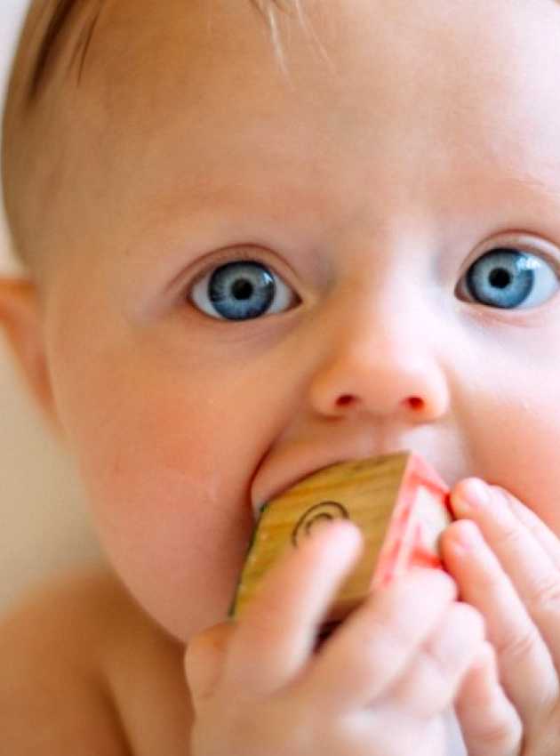 bébé aux yeux bleus qui fait ses dents