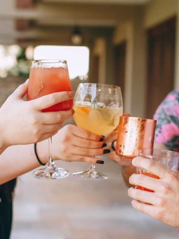femmes et hommes en été avec un cocktail dans les mains