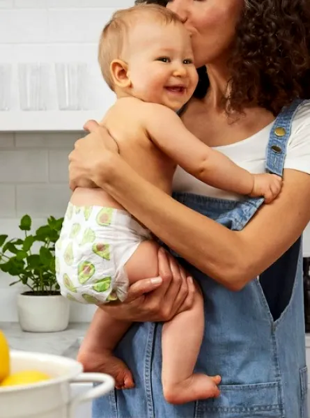 femme tenant son bébé dans les bras dans une cuisine