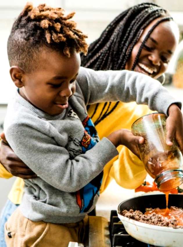 mère avec son fils souriants et cuisinant