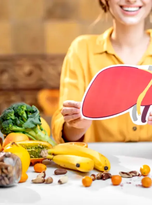 A person holding up a liver surrounded by fruits and vegetables. Nutritionnistes : acteurs clés de la  gestion de la stéatose hépatique métabolique