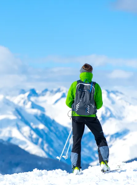 Homme sur une montagne enneigée regardant au loin