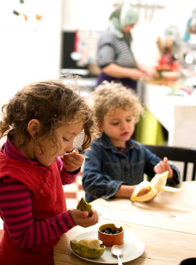 deux fillettes qui goûtent à des fruits