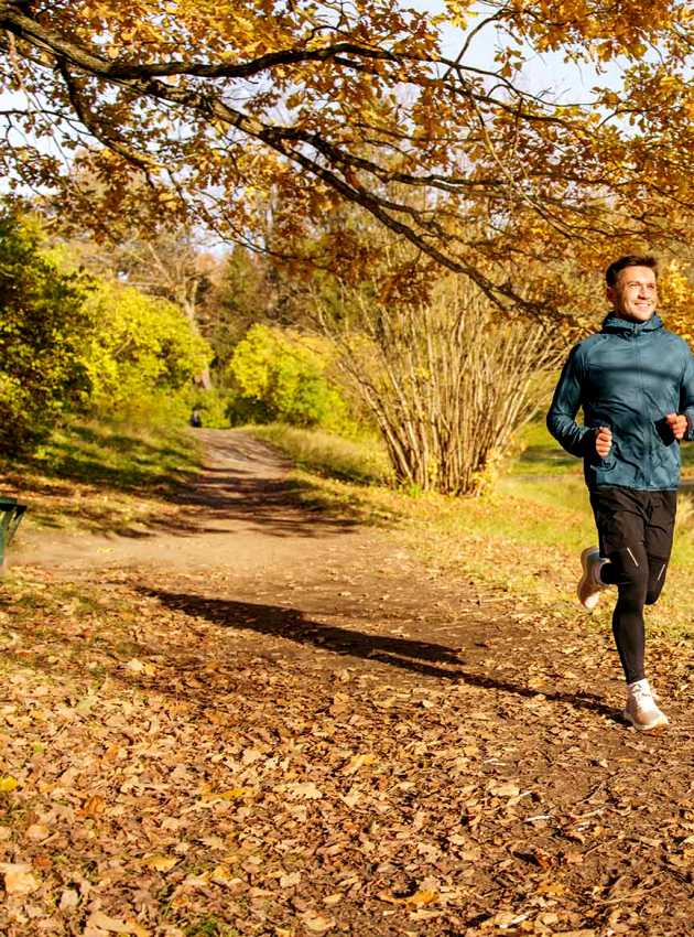 Homme courant sur un sentier d'automne - Man jogging on a leafy autumn trail