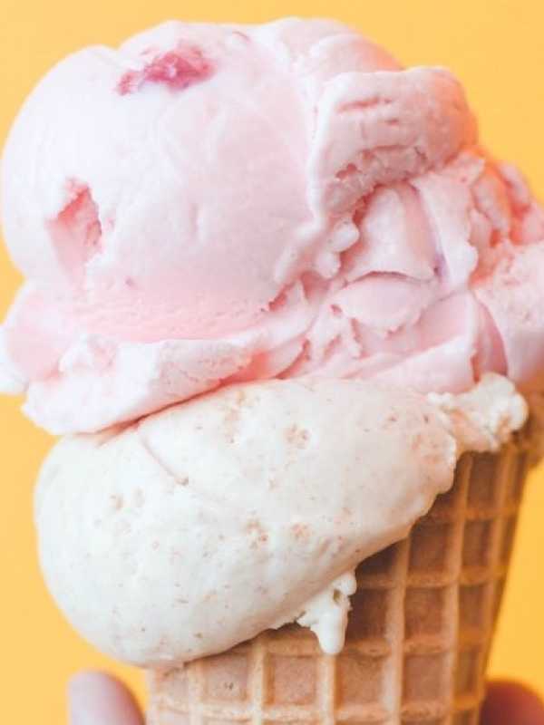cornet de crème glacé rose et blanche sur fond orange