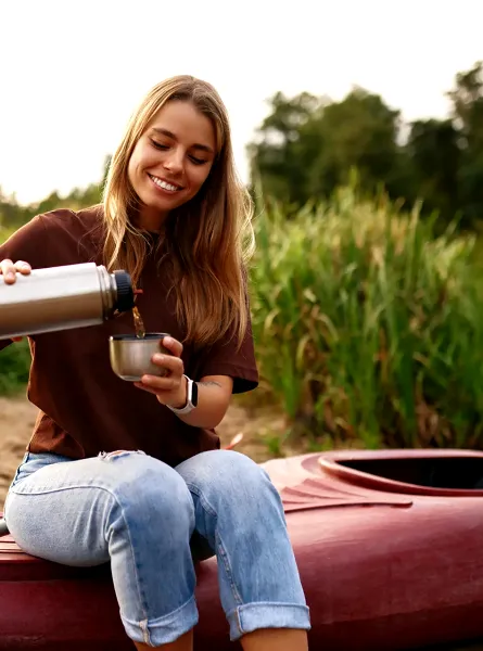 femme qui se verse une boisson assise sur un kayak à Cap-Rouge ÉquipeNutrition TeamNutrition