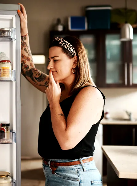 Femme regardant dans le réfrigérateur - Woman looking at fridge content