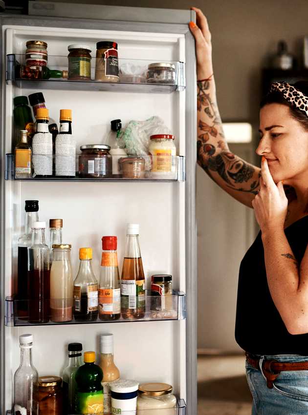 Femme regardant dans le réfrigérateur - Woman looking at fridge content