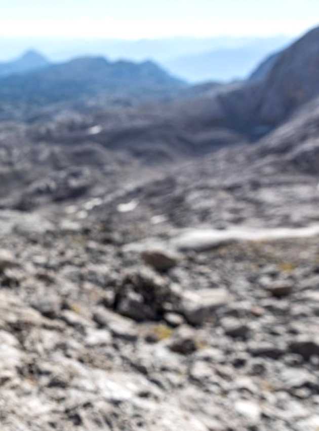 Mains ouvrant une bouteille d'eau en montagne.