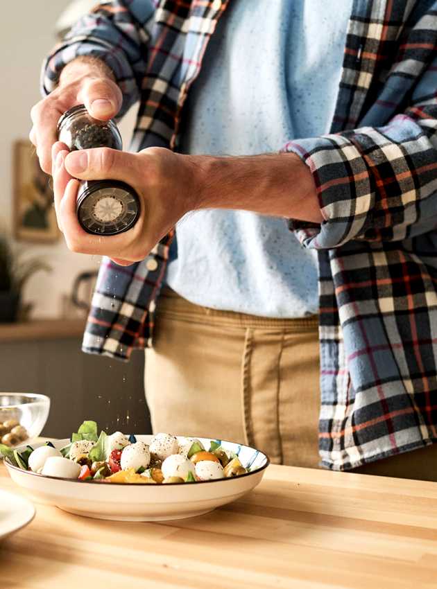 Homme ajoutant épices sur salade - Man adding spices on salad