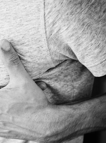 homme avec les mains sur le torse à cause de reflux gastriques